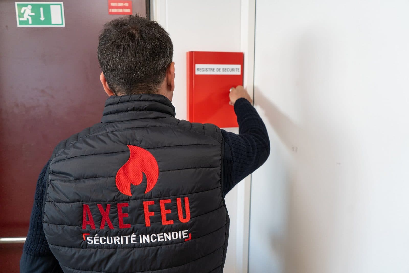 Technicien AXE FEU contrôlant le registre de sécurité d'un établissement